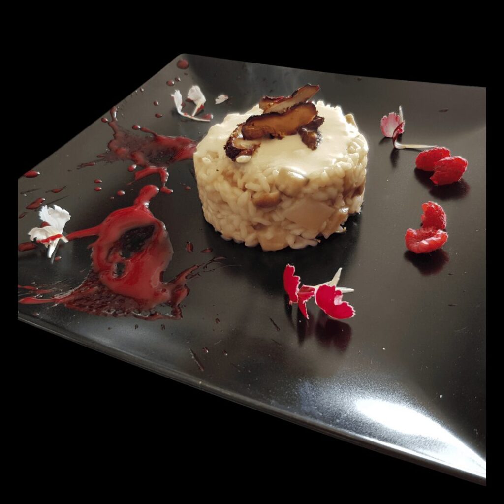 Fotografia di un tortino di risotto ai funghi con fiori commestibili.